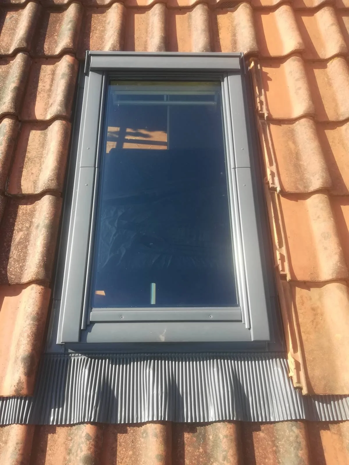 Blecheinfassung eines Dachfensters in einem Ziegeldach